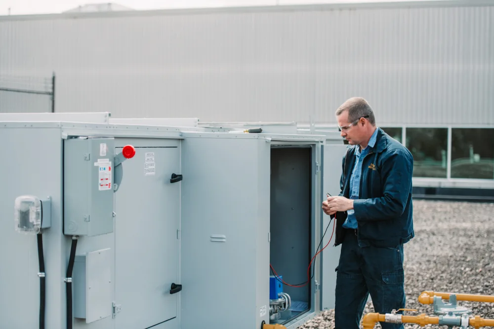 Denaeyer technician working on a commercial rooftop unit.