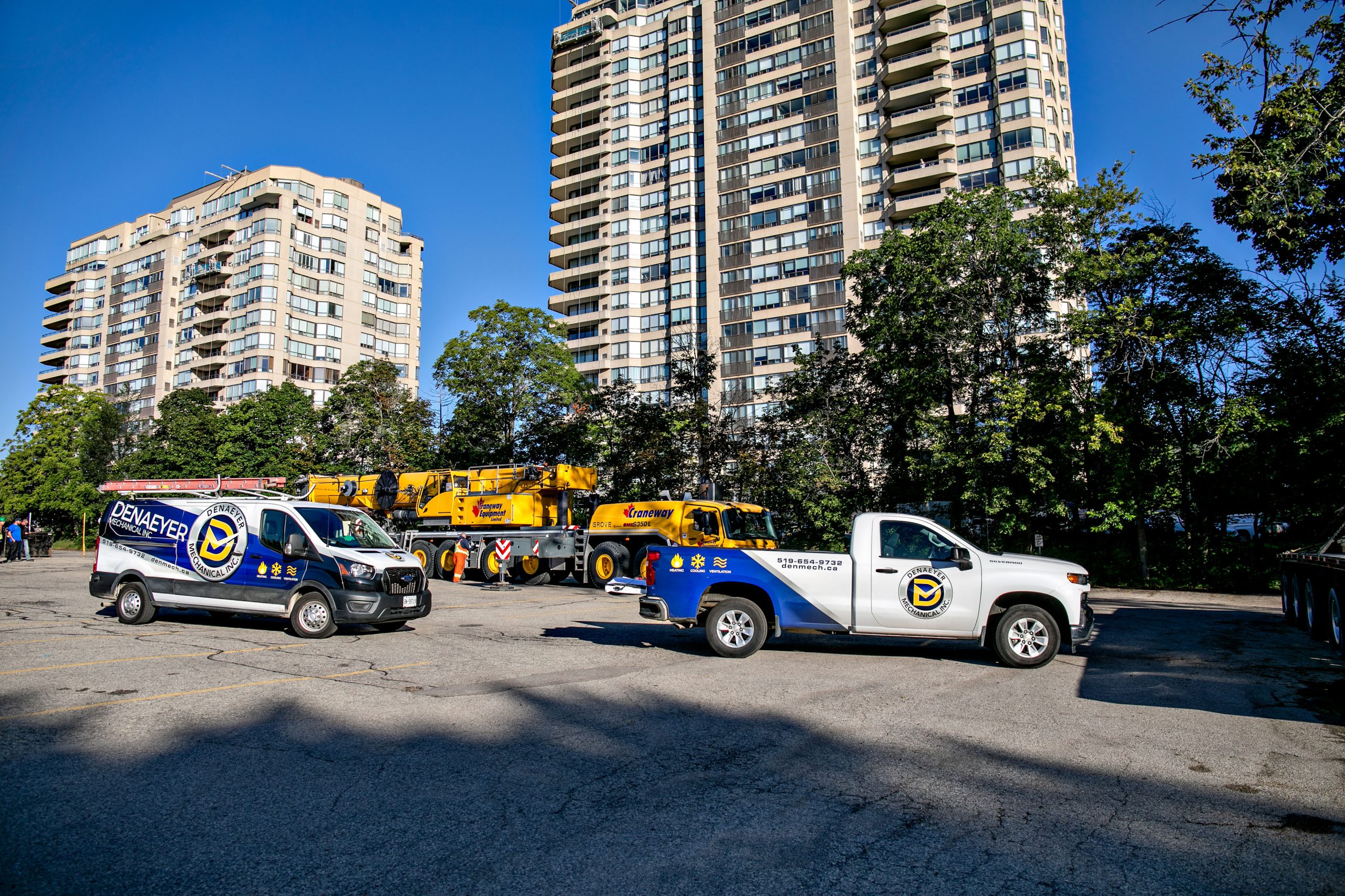 Denaeyer vehicles and a crane beside the Waterpark Place condominium towers.