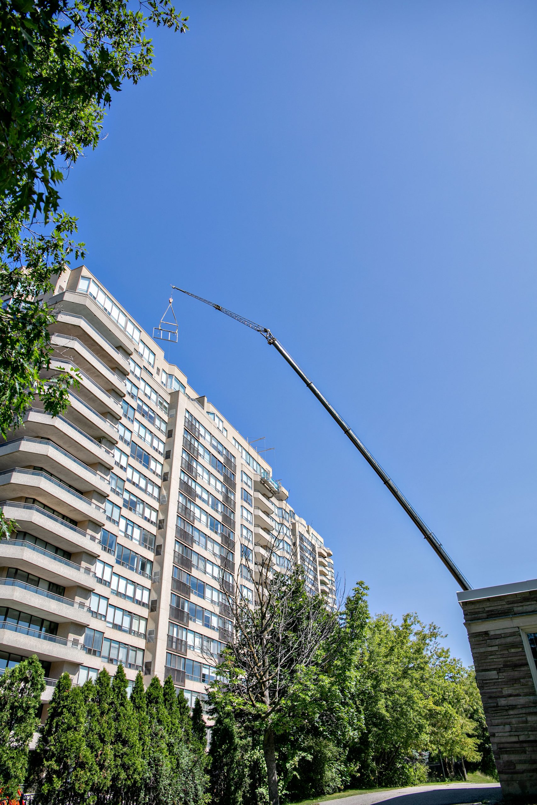 Crane boom extended beside a Waterpark Place condominium tower.